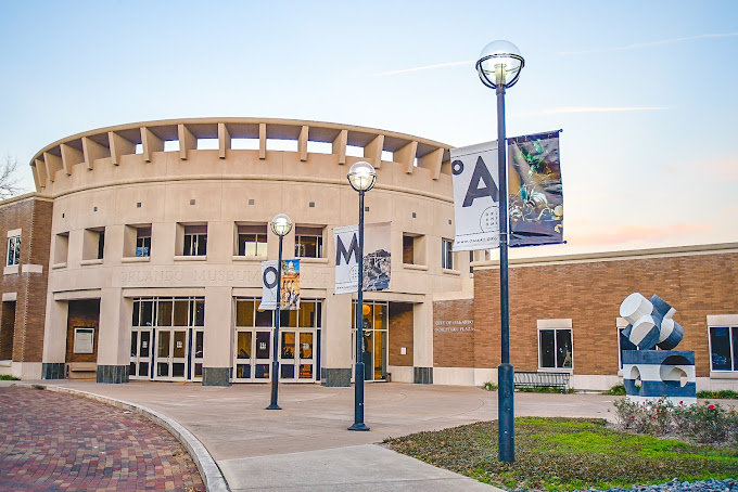 outside of circular building with square cutouts and OMA signage